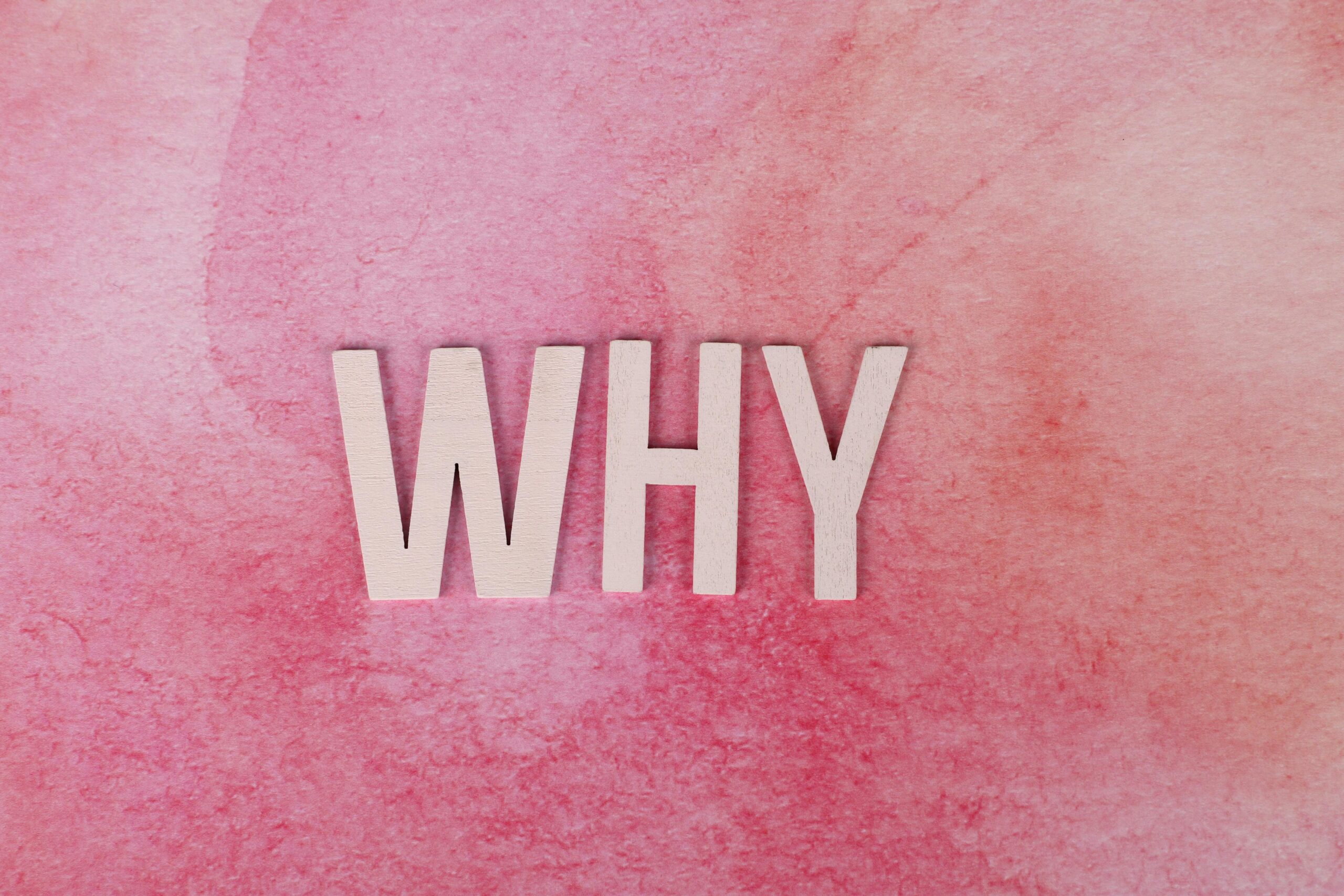 Bold white letters spelling WHY on a pink textured background for conceptual design.