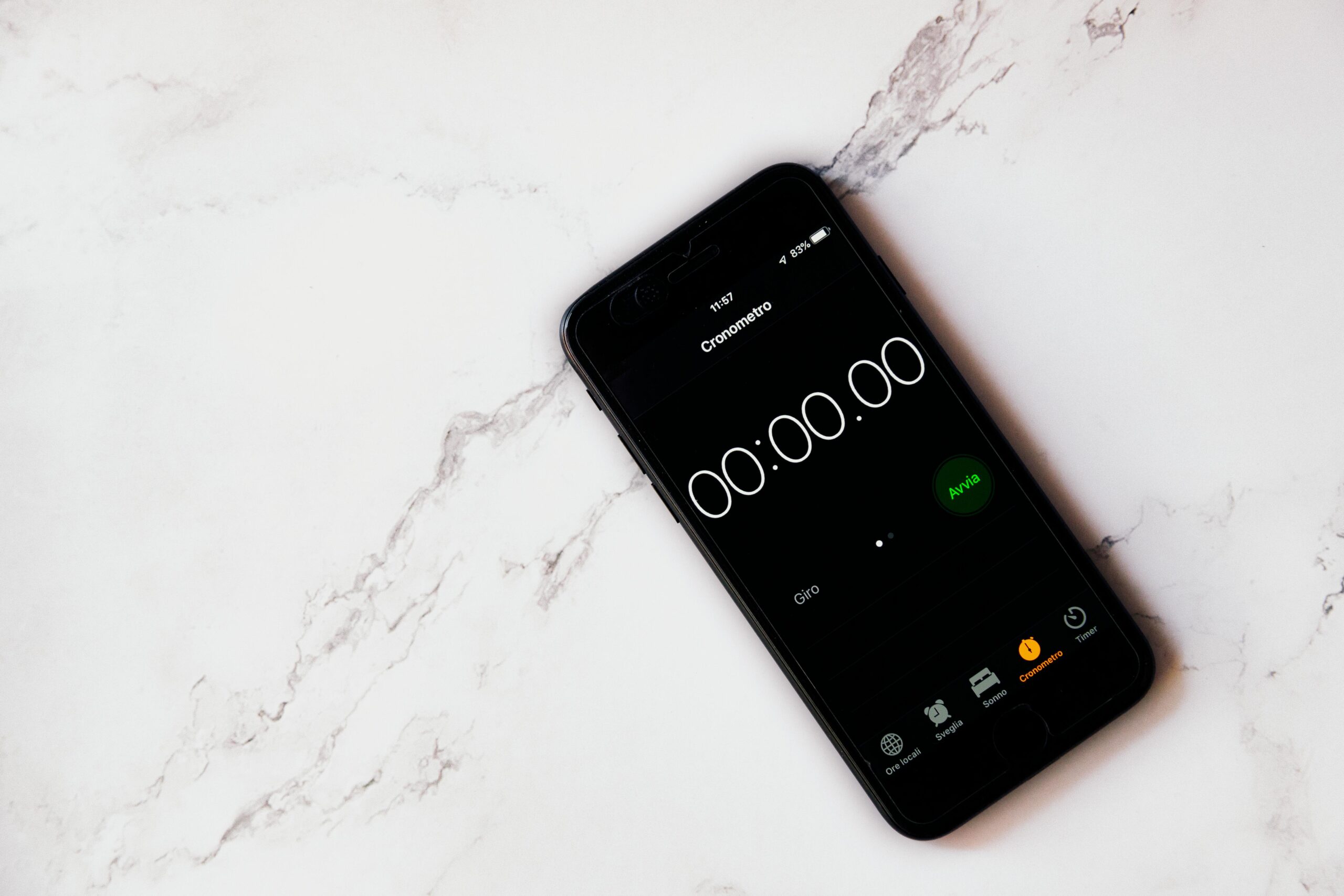 Close-up of a smartphone displaying a stopwatch on a marble surface.